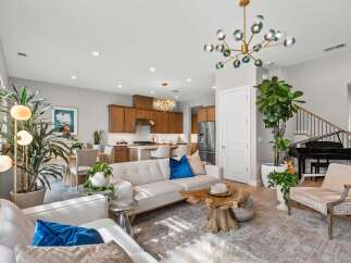 Experience modern living in this spacious open-concept home, featuring a gourmet kitchen with rich wood cabinetry and a stunning crystal chandelier.
