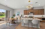 Experience modern living in this stunning kitchen and dining area, featuring a large marble island with bar seating and a beautiful crystal chandelier.