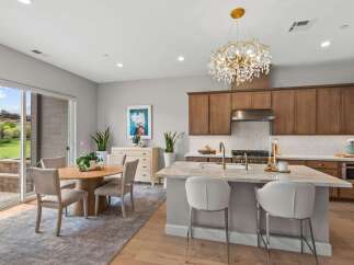 Experience modern living in this stunning kitchen and dining area, featuring a large marble island with bar seating and a beautiful crystal chandelier.