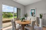 Enjoy scenic views from this dining area, featuring a round wooden table with four upholstered chairs.