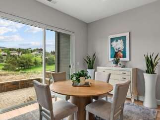 Enjoy scenic views from this dining area, featuring a round wooden table with four upholstered chairs.