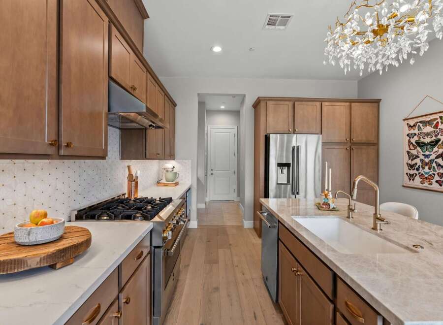 Experience luxury in this stunning kitchen featuring sleek, modern cabinetry and a spacious island with a farmhouse sink.