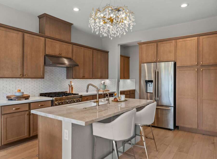 Experience luxury in this stunning kitchen featuring custom wood cabinetry and a sleek stainless steel appliance suite.