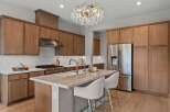 Experience luxury in this stunning kitchen featuring custom wood cabinetry and a sleek stainless steel appliance suite.
