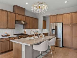 Experience luxury in this stunning kitchen featuring custom wood cabinetry and a sleek stainless steel appliance suite.