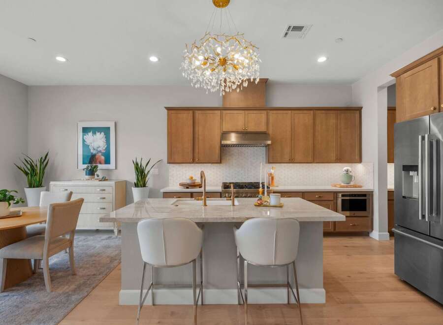 Experience luxury living in this stunning kitchen featuring elegant wood cabinetry and a spacious marble island perfect for entertaining.