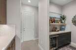 Discover this stylish wet bar, perfect for entertaining, featuring a built-in wine fridge and a chic coffee station.