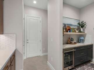 Discover this stylish wet bar, perfect for entertaining, featuring a built-in wine fridge and a chic coffee station.