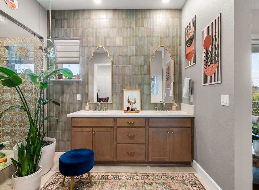 This stunning bathroom features a spacious double vanity with elegant gold-framed mirrors and modern brass fixtures.