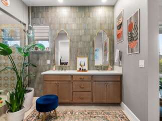 This stunning bathroom features a spacious double vanity with elegant gold-framed mirrors and modern brass fixtures.