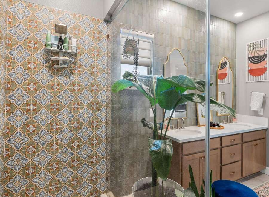Step into a beautifully designed bathroom featuring a stunning patterned tile shower and a spacious double vanity.
