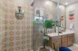 Step into a beautifully designed bathroom featuring a stunning patterned tile shower and a spacious double vanity.