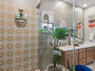 Step into a beautifully designed bathroom featuring a stunning patterned tile shower and a spacious double vanity.