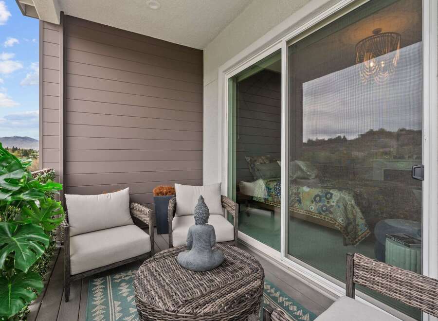 Enjoy your morning coffee or evening relaxation on this charming balcony, featuring comfortable seating and a serene Buddha statue.