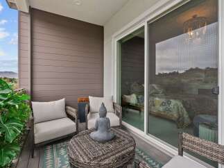 Enjoy your morning coffee or evening relaxation on this charming balcony, featuring comfortable seating and a serene Buddha statue.
