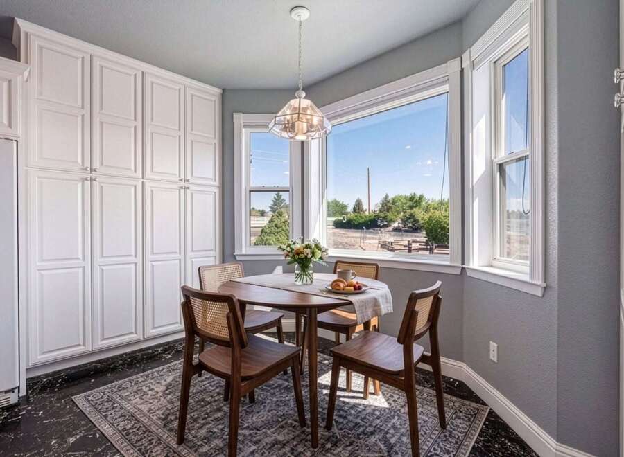 Enjoy your morning coffee in this charming breakfast nook, bathed in natural light from the large bay windows.