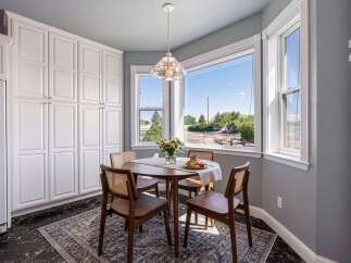 Enjoy your morning coffee in this charming breakfast nook, bathed in natural light from the large bay windows.