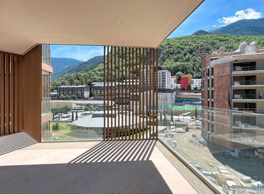 Experience modern living with this stunning balcony offering panoramic mountain views and a unique slatted wood design.