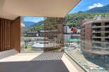 Experience modern living with this stunning balcony offering panoramic mountain views and a unique slatted wood design.