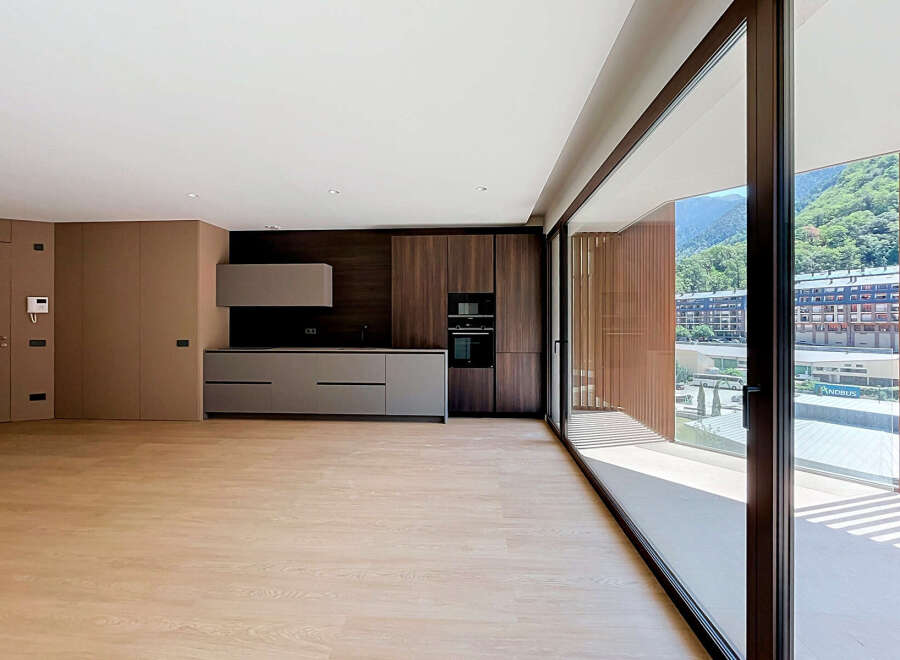 Experience modern living in this spacious, open-plan apartment featuring a sleek, integrated kitchen with ample cabinet space and built-in appliances.