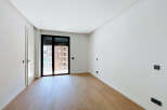 Discover this bright and airy room featuring a modern design with clean white walls and elegant light wood flooring.
