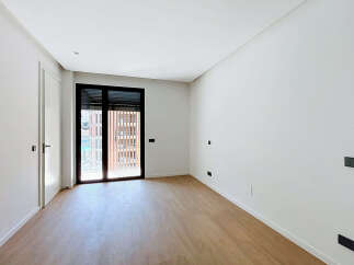 Discover this bright and airy room featuring a modern design with clean white walls and elegant light wood flooring.
