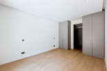 Discover modern living in this unfurnished bedroom, featuring sleek grey built-in wardrobes and a minimalist aesthetic.