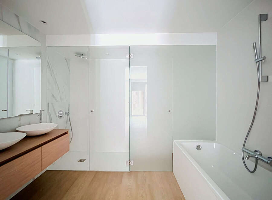 Experience modern luxury in this stunning bathroom featuring a spacious walk-in shower with sleek glass doors and a freestanding bathtub.