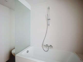 This modern bathroom features a sleek white bathtub with a chrome showerhead and faucet, perfect for a relaxing soak.