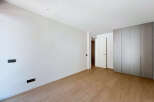 Experience modern living in this spacious, unfurnished room featuring sleek, built-in wardrobes and a clean, minimalist aesthetic.
