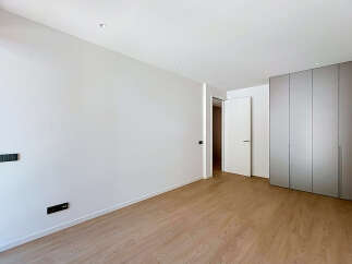 Experience modern living in this spacious, unfurnished room featuring sleek, built-in wardrobes and a clean, minimalist aesthetic.