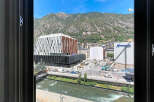 Experience modern living with this stunning view overlooking a vibrant cityscape and majestic mountains.