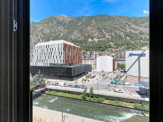 Experience modern living with this stunning view overlooking a vibrant cityscape and majestic mountains.