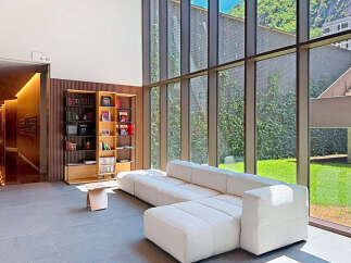 Experience modern living in this spacious apartment lobby, featuring a comfortable sectional sofa and a stylish bookshelf filled with literature.