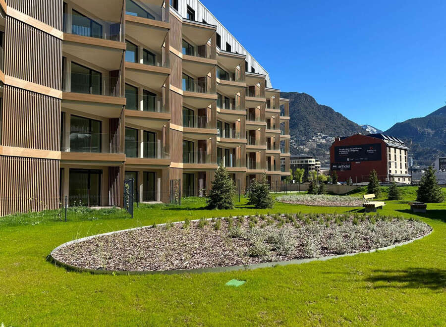 Experience modern living in this stunning apartment complex, featuring a unique architectural design with wood-paneled facades and expansive balconies offering breathtaking mountain views.