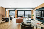 Experience luxury living with this stunning open-concept living and dining area, featuring a modern fireplace and expansive windows that showcase breathtaking mountain views.