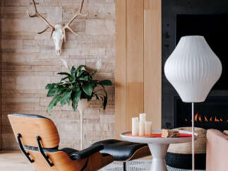 Experience modern living in this stylish room featuring a unique Eames lounge chair and ottoman, perfect for relaxation.