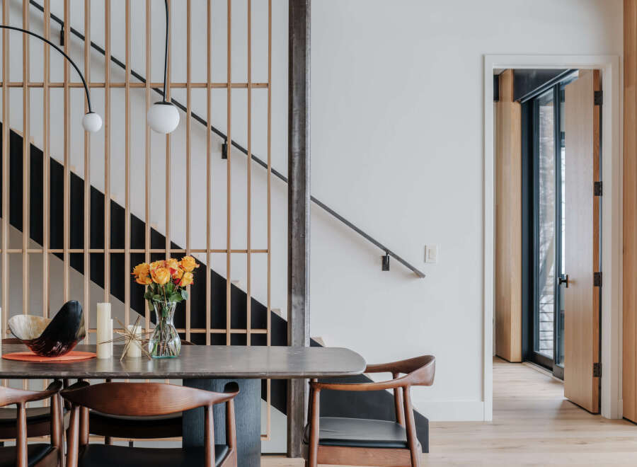 Experience modern living with this stunning dining area featuring a sleek stone-top table and comfortable wooden chairs.