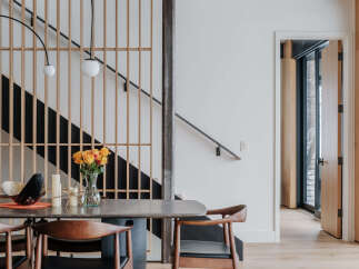Experience modern living with this stunning dining area featuring a sleek stone-top table and comfortable wooden chairs.