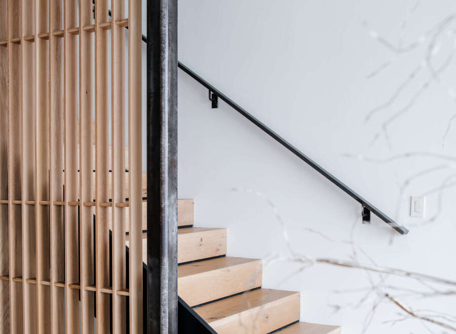 Experience modern living with this stunning staircase featuring natural wood treads and a sleek black riser.