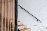 Experience modern living with this stunning staircase featuring natural wood treads and a sleek black riser.