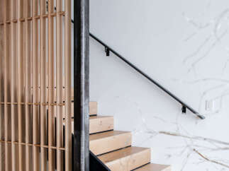 Experience modern living with this stunning staircase featuring natural wood treads and a sleek black riser.