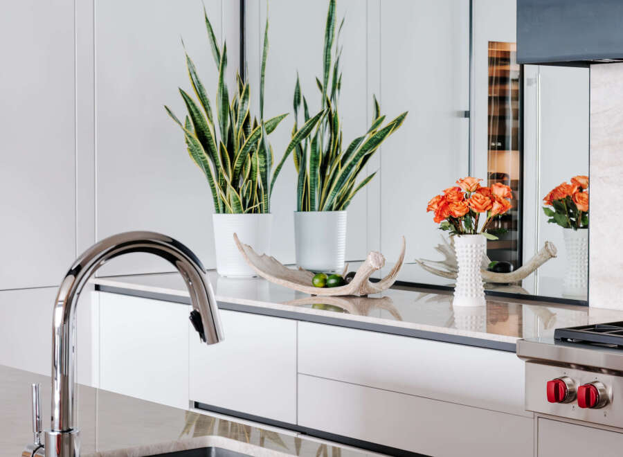 Experience modern luxury in this stunning kitchen, featuring sleek white cabinetry and a polished marble countertop.