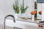Experience modern luxury in this stunning kitchen, featuring sleek white cabinetry and a polished marble countertop.