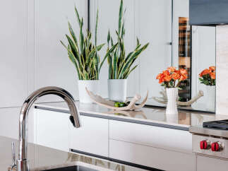 Experience modern luxury in this stunning kitchen, featuring sleek white cabinetry and a polished marble countertop.