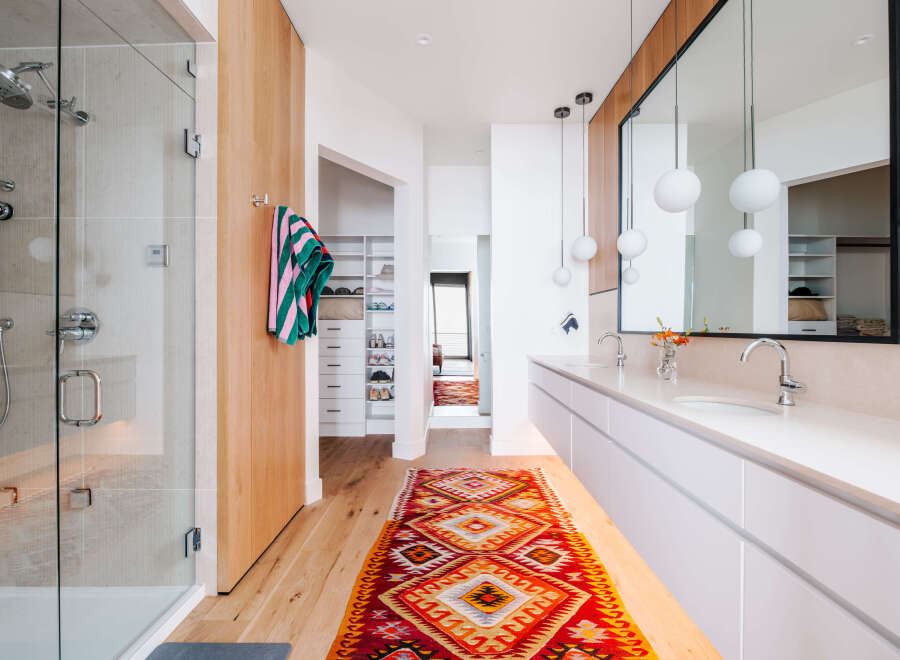 Experience modern luxury in this stunning bathroom, featuring a spacious glass-enclosed shower and a sleek double vanity with contemporary pendant lighting.