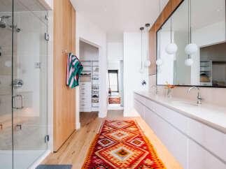Experience modern luxury in this stunning bathroom, featuring a spacious glass-enclosed shower and a sleek double vanity with contemporary pendant lighting.