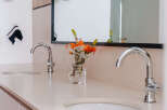 Experience modern luxury in this stunning bathroom featuring a dual vanity with sleek chrome faucets and integrated sinks.