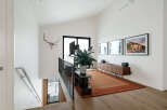 This modern living space features a vaulted ceiling and a large window offering scenic views.