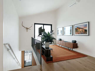 This modern living space features a vaulted ceiling and a large window offering scenic views.